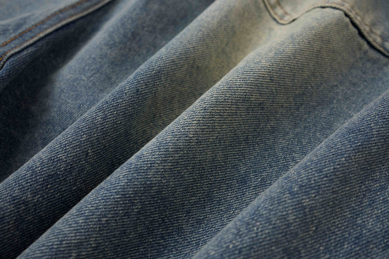Close-up of blue denim fabric with diagonal weave and faded texture