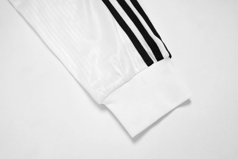 White sleeve cuff with two black stripe details on layered long sleeve tee