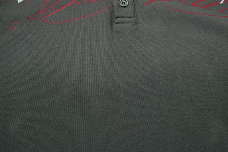 Dark gray vintage polo tee with red abstract graphic and button placket, close-up cotton streetwear shirt texture