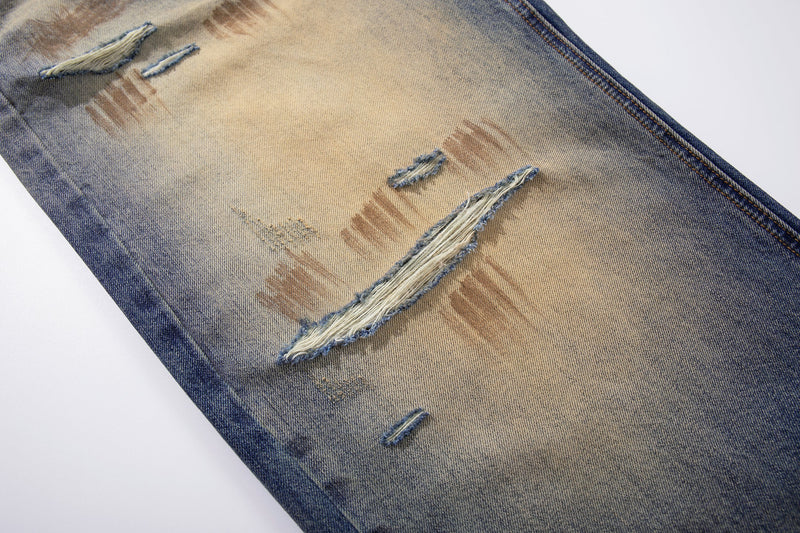 Close-up of ripped leg panels on gradient wash denim jeans