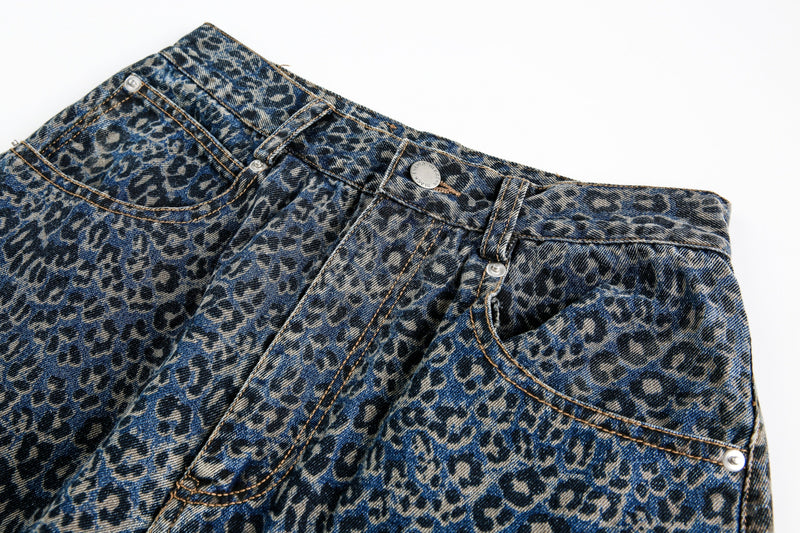 Close-up of blue leopard print jeans showing waistband, pocket, and button detail