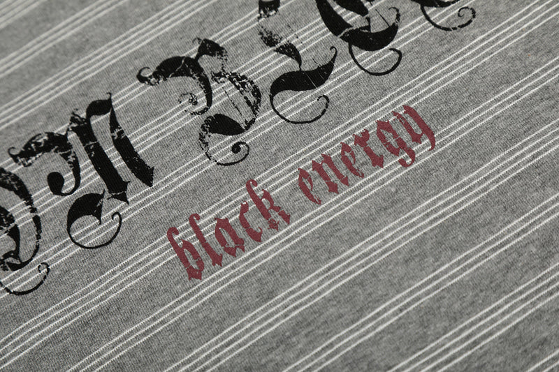 Close-up of red black energy text beneath Gothic logo on gray striped tee
