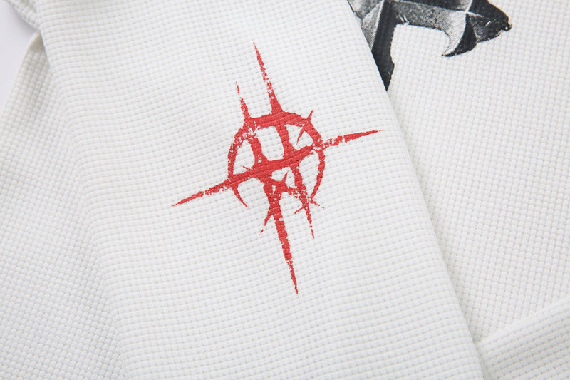 Close-up of red symbol print on white sleeve with black cross graphic in background