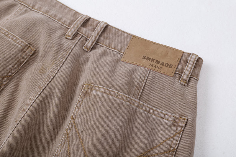 Close-up of brown jeans back pocket area with logo patch