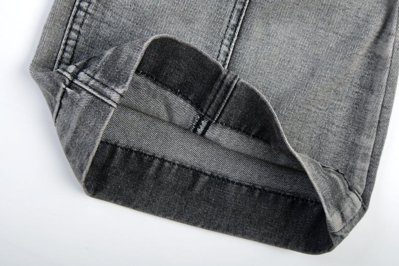 Cuffed hem close-up of grey wash denim flare jeans showing inside seam and heavy hem
