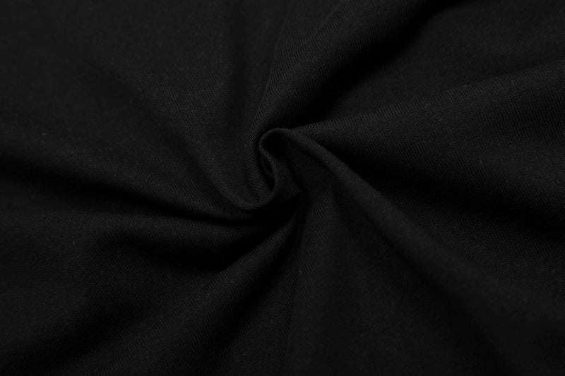 Black fabric close-up with soft folds and ribbed texture, showing the material of a streetwear graphic tee