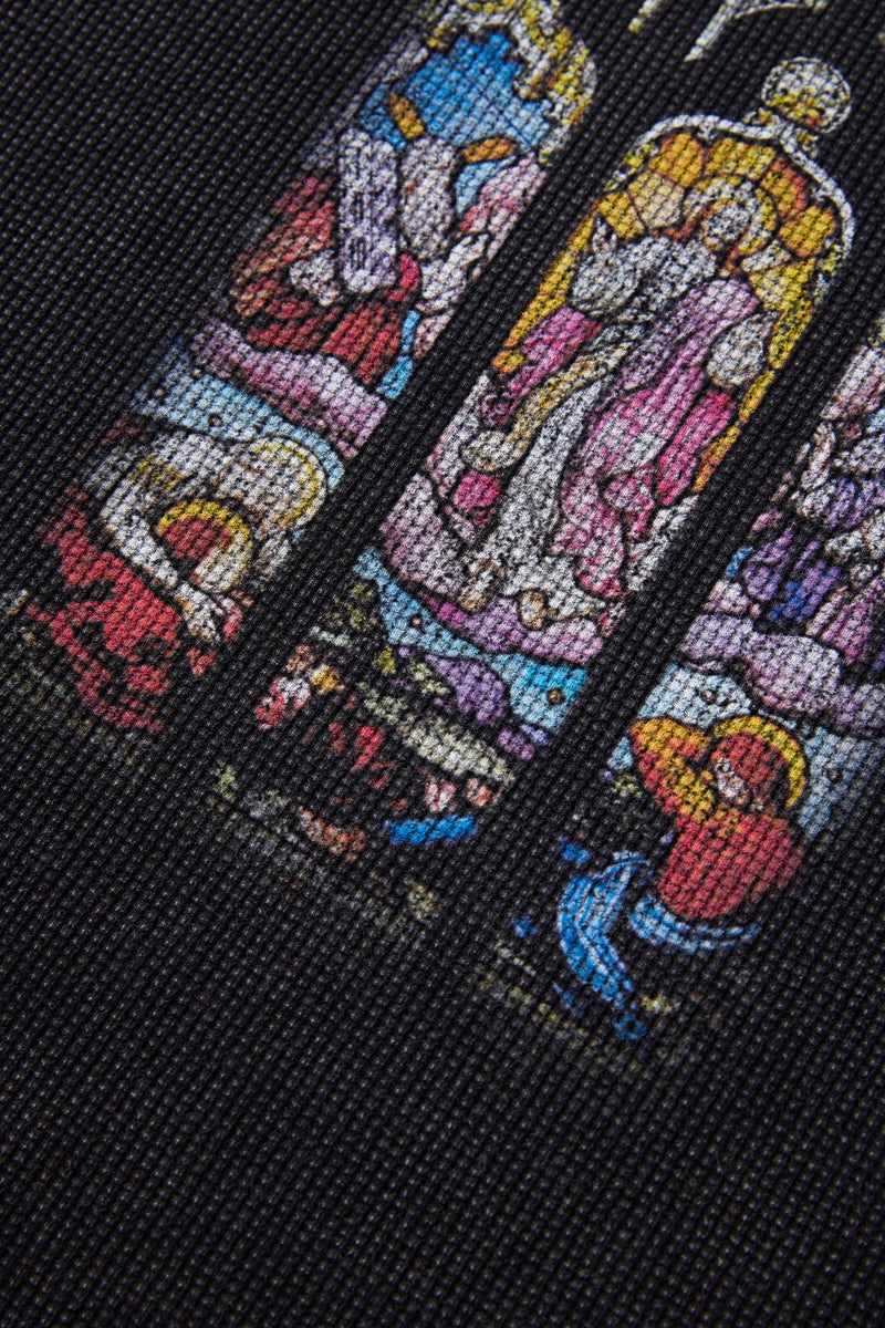 Close-up of a black T-shirt with colorful stained glass soul graphic in blue, pink, yellow, and red tones