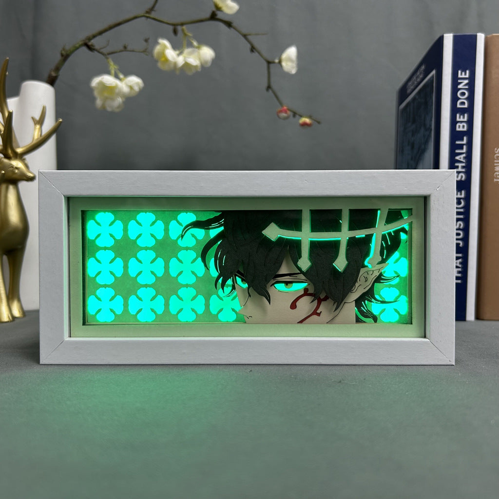 The Black Clover Anime Light Box, featuring the Asta Devil Union Form in a striking 3D effect, showcases an anime character with black hair and red eyes on the right side. It includes a green glow with clover designs, accented by a gold deer and white flowers. The LED light offers 16 adjustable colors.