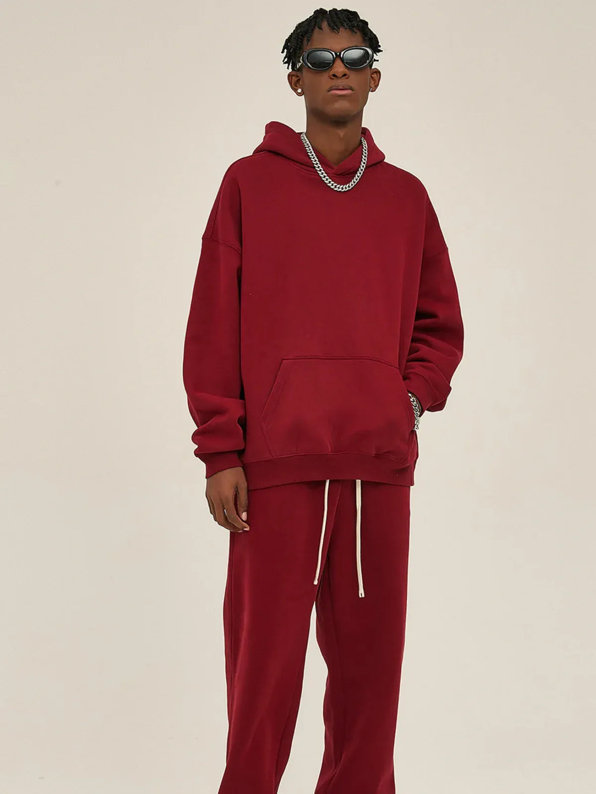 Person wearing a Custom Anime Character Burgundy Hoodie—Personalized 350GSM 100% Cotton Pullover—styled with sunglasses, a silver chain, and a wristwatch, standing against a plain light background.