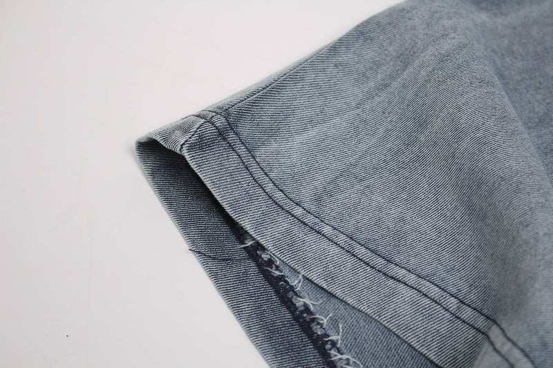 Close-up of a vintage washed gray graphic T-shirt sleeve with distressed frayed hem and visible stitching