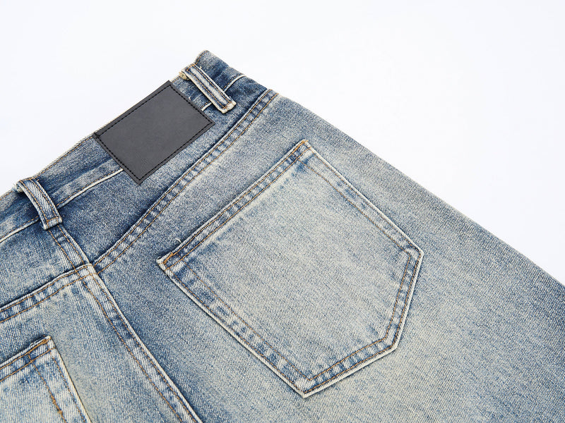 Close-up of back pocket and waistband detail on faded blue jeans