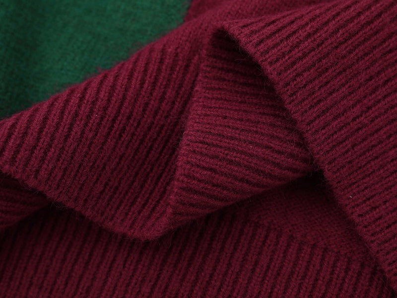 Close-up of burgundy sleeve hem beside green knit side panel