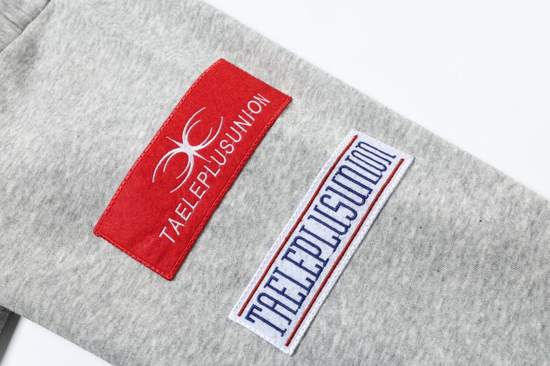 Close-up of red and white sleeve patches on gray sweatshirt