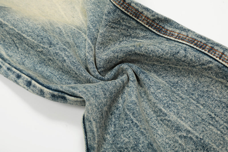 Close-up of light wash jeans leg with twisted denim texture and faded finish