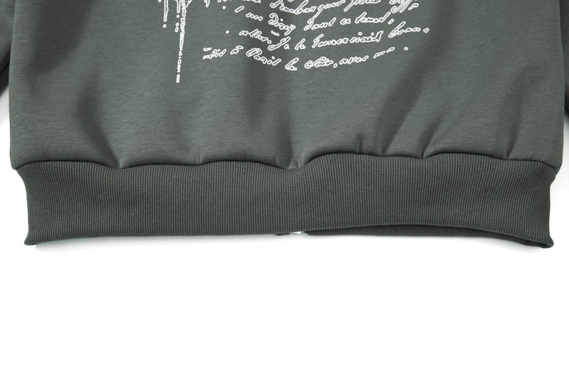 Close-up of lower back hem and print on dark green hoodie