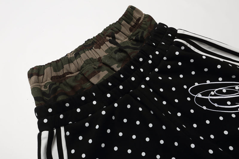 Close-up of the waistband and upper side of black polka dot shorts with camo trim