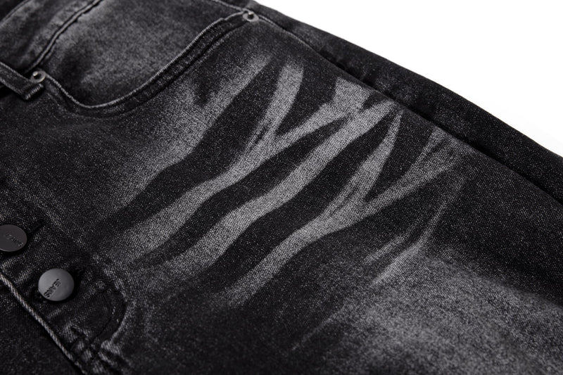 Close-up of black washed denim with zebra-like faded stripe pattern