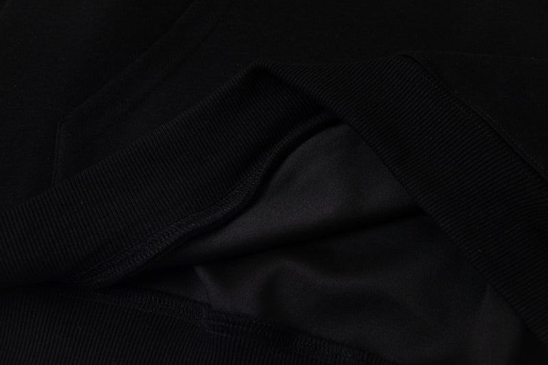 Close-up of black hoodie's ribbed cuff and gathered sleeve seam