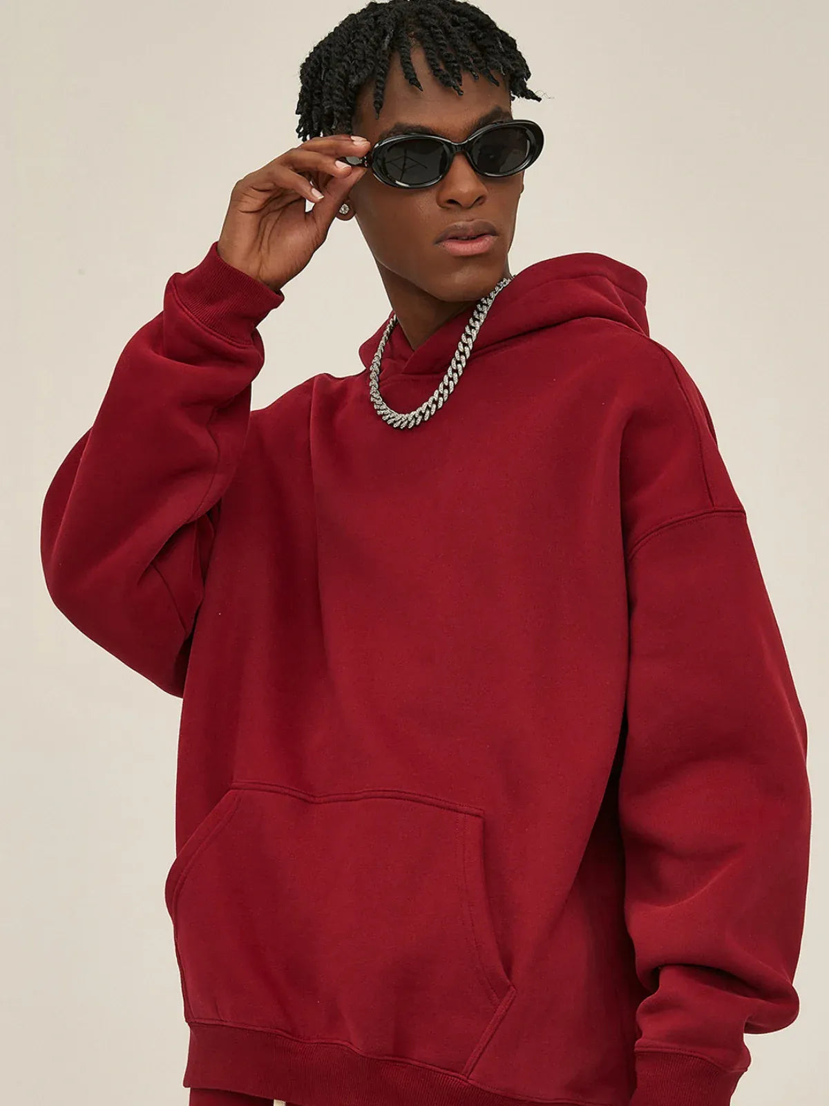Person wearing a Custom Anime Character Burgundy Hoodie – Personalized 350GSM 100% Cotton Pullover, paired with a silver chain necklace and black sunglasses, stands against a plain background with one hand near their sunglasses.