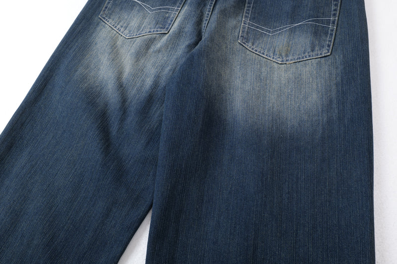 Close-up of back pockets on dark blue wide-leg jeans with faded wash