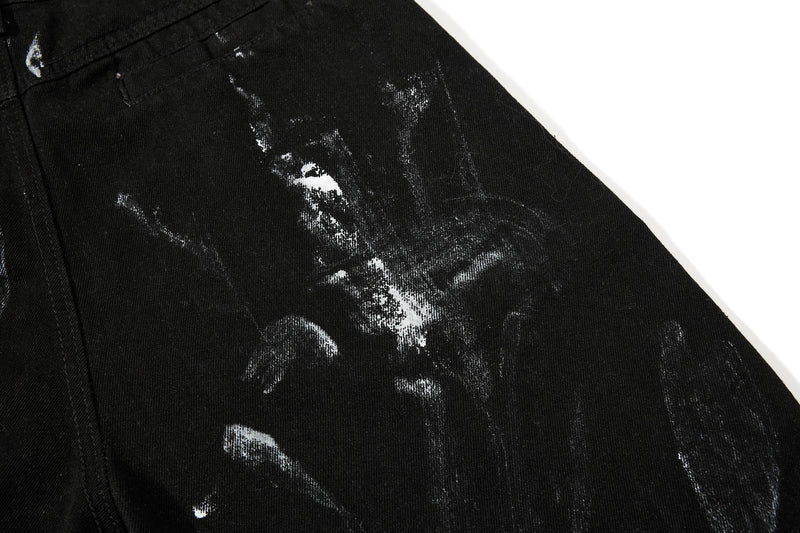 Close-up of black denim leg with distressed white wash marks