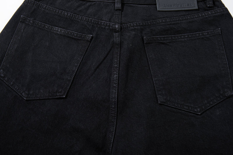 Close-up of the back pockets on black denim jeans with contrast stitching