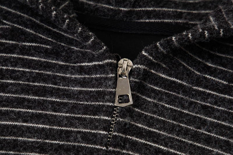 Close-up of black striped knit hoodie zipper and fuzzy textured fabric