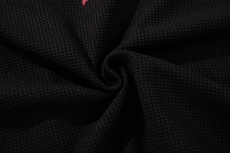 Close-up of black textured ringer T-shirt fabric with a subtle distressed vintage streetwear look