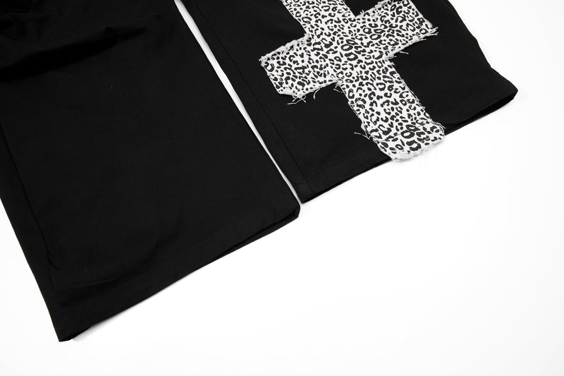Black cargo pants lower leg with frayed leopard-print cross patch detail