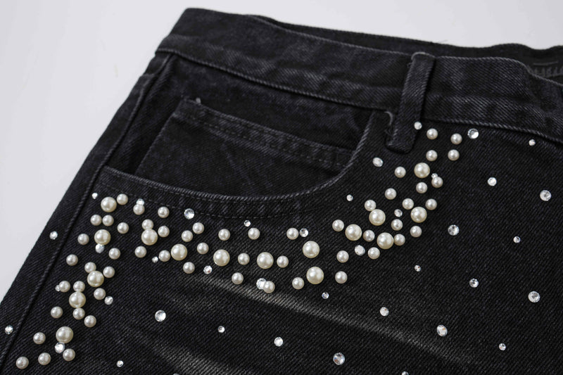 Close-up of black denim back pocket with pearl studs