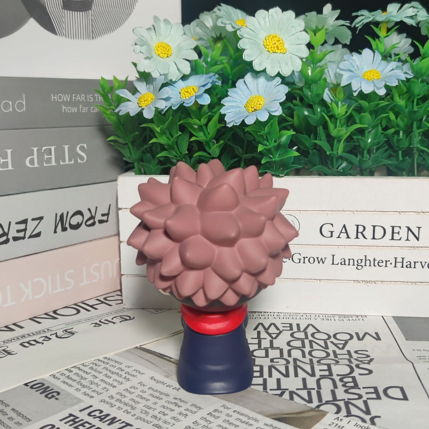 The Itadori Yuji Anime Figure, a 12cm static pose collectible by Jujutsu Kaisen, features spiky hair and stands on a base amidst boxes, newspapers, and decorative flowers—ideal for collectors.