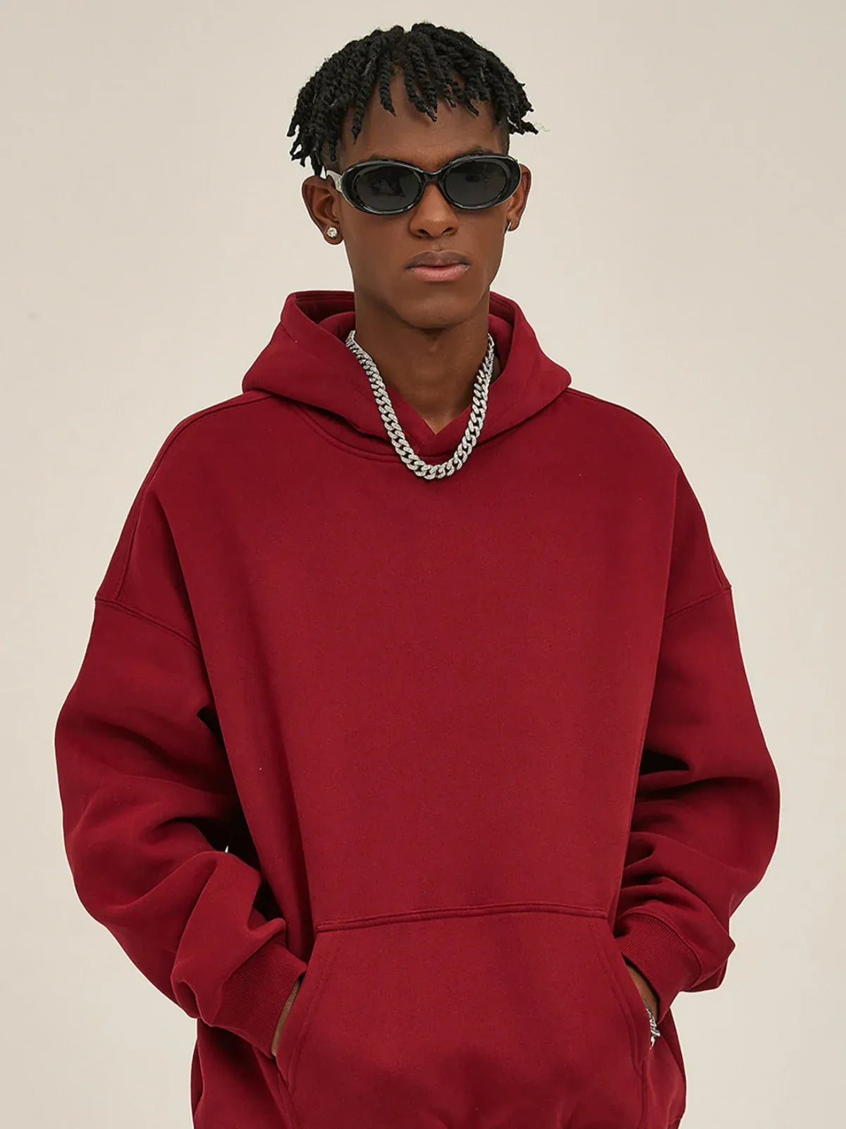 Model wearing the Custom Anime Character Burgundy Hoodie - Personalized 350GSM 100% Cotton Pullover, paired with dark sunglasses and a silver chain, stands with hands in pockets against a light background.