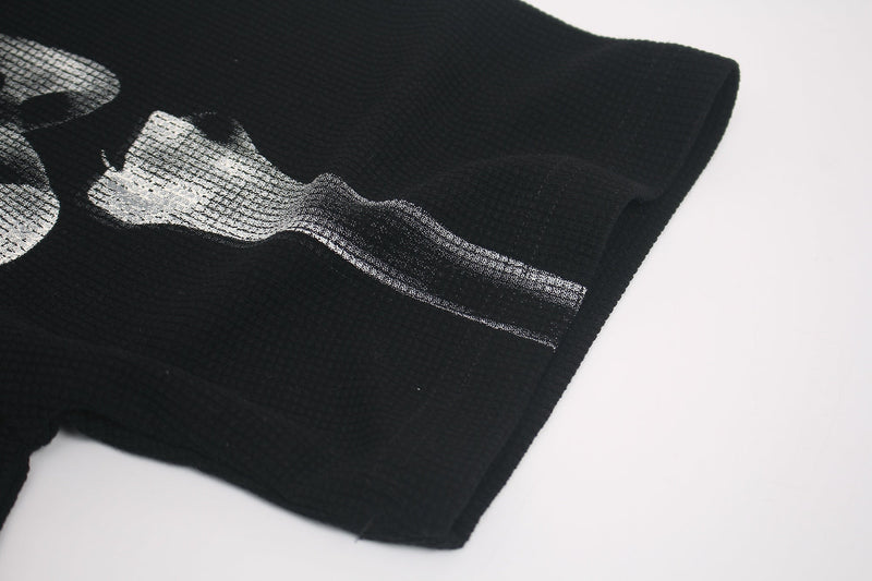 Black oversized graphic tee with a distressed white x-ray skeleton print on the sleeve and chest