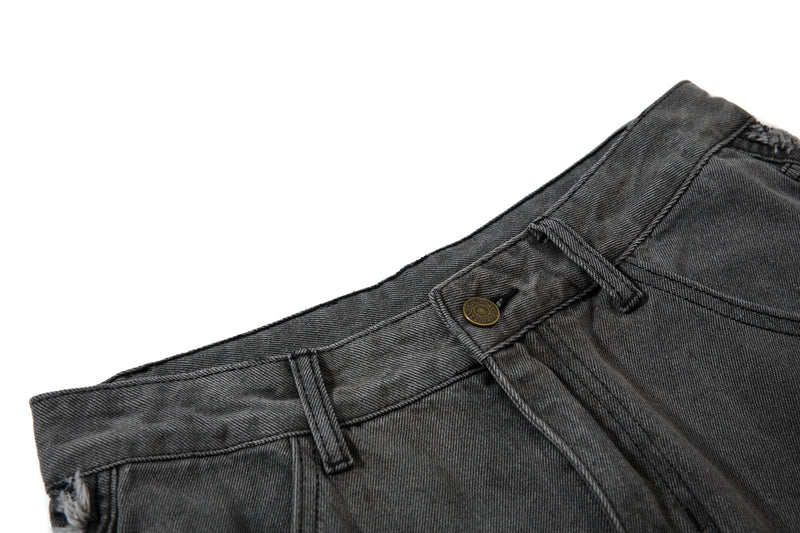 Close-up of black denim waistband with belt loops and top button