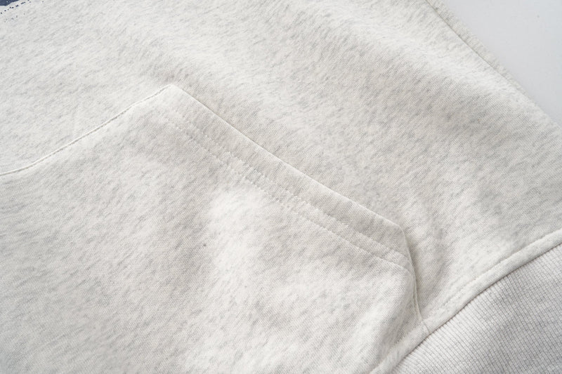 Close-up of kangaroo pocket stitching on heather gray hoodie