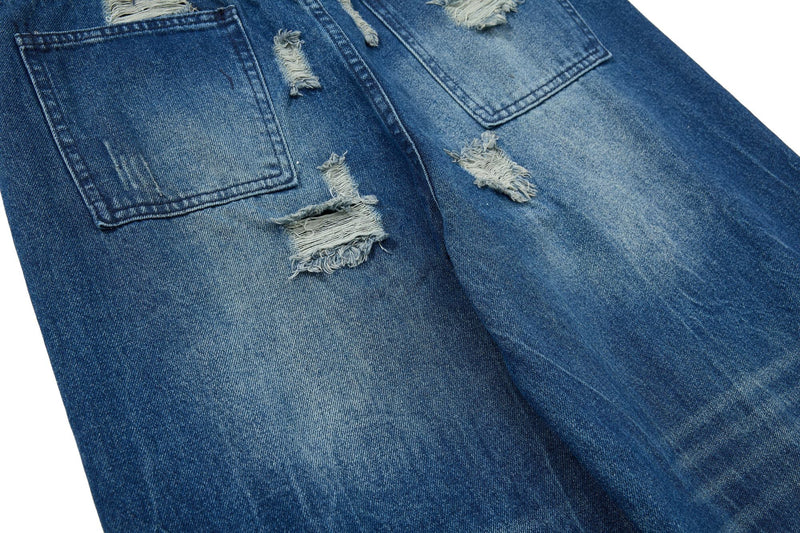 Back pocket and torn patch detail on faded blue wide-leg jeans