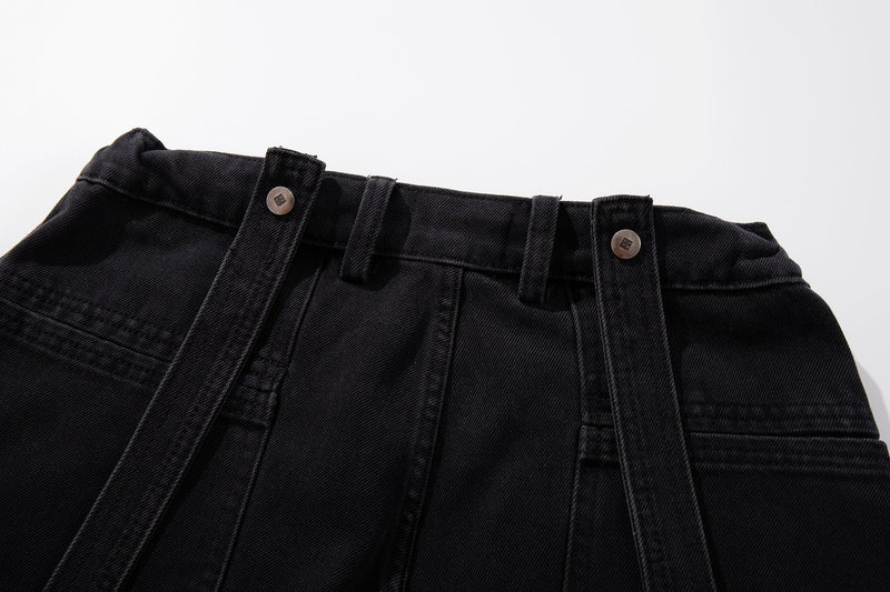 Close-up of waistband with belt loops and snap buttons on dark washed denim jeans