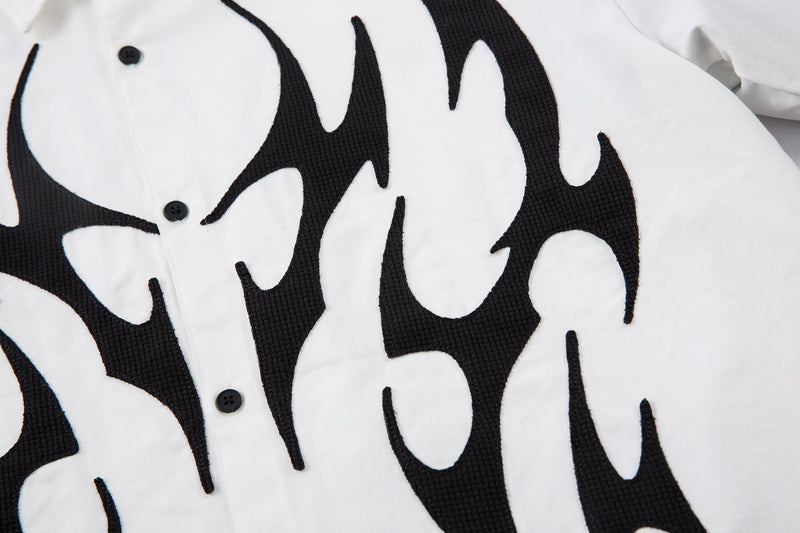 Close-up of white shirt front with bold black flame design and button placket