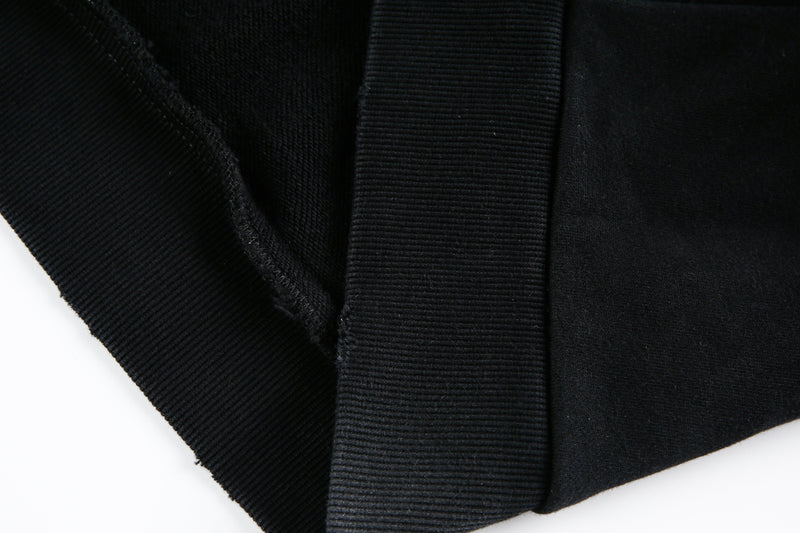 Close-up of ribbed hem and side seam on black hoodie