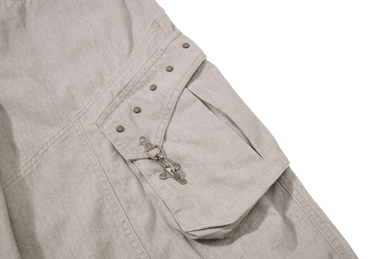 Beige cargo pocket detail with snap flap and metal buckle strap