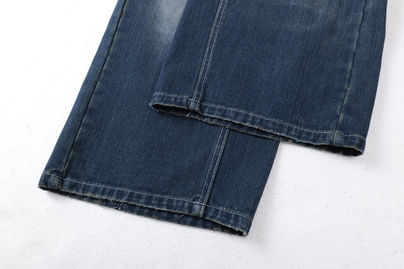 Close-up of wide-leg jean hems with frayed edges and dark blue denim