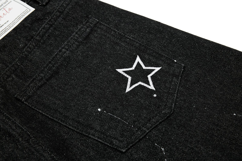 Close-up of back pocket with white embroidered star on black jeans