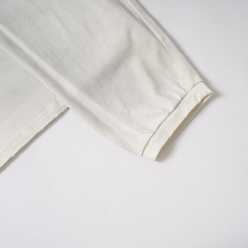 Sleeve cuff close-up on cream long sleeve tee with visible stitching