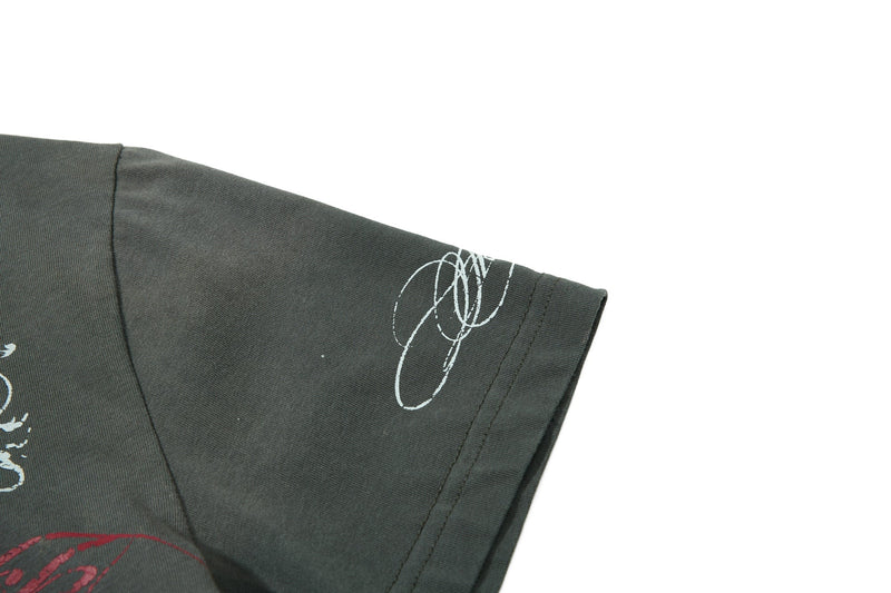 Dark gray vintage graphic polo tee with abstract white sleeve print and retro streetwear styling