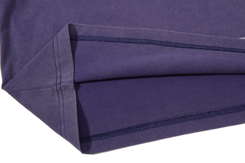 Close-up of a washed purple vintage streetwear tee with visible hem stitching and folded sleeve detail