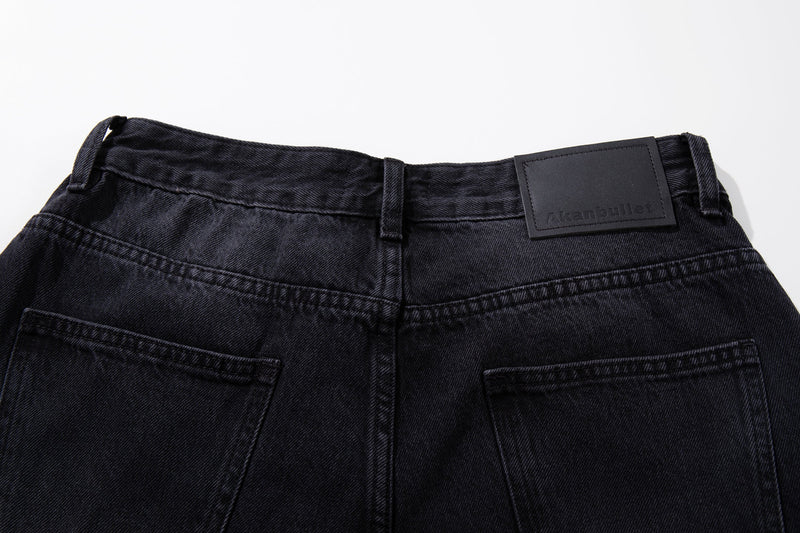 Back waistband of dark wash jeans with black brand patch and belt loops