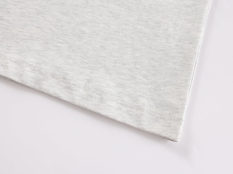 Close-up of heather gray tee hem with visible stitching