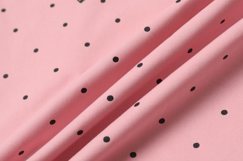 Close-up of pink fabric with black polka dots and soft drape