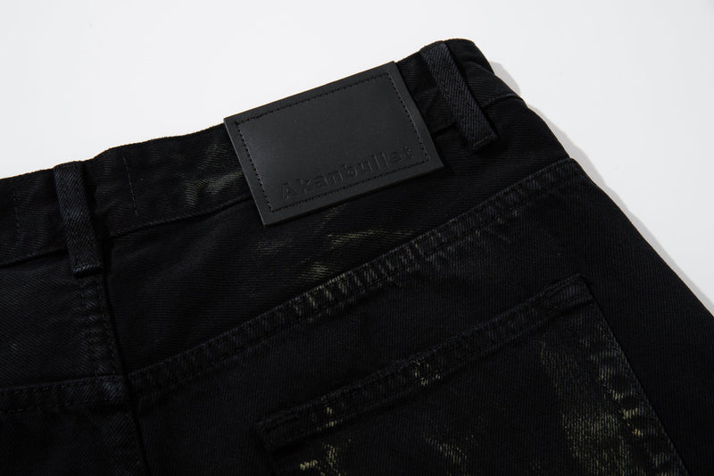 Close-up of back waistband and branded patch on black washed denim jeans