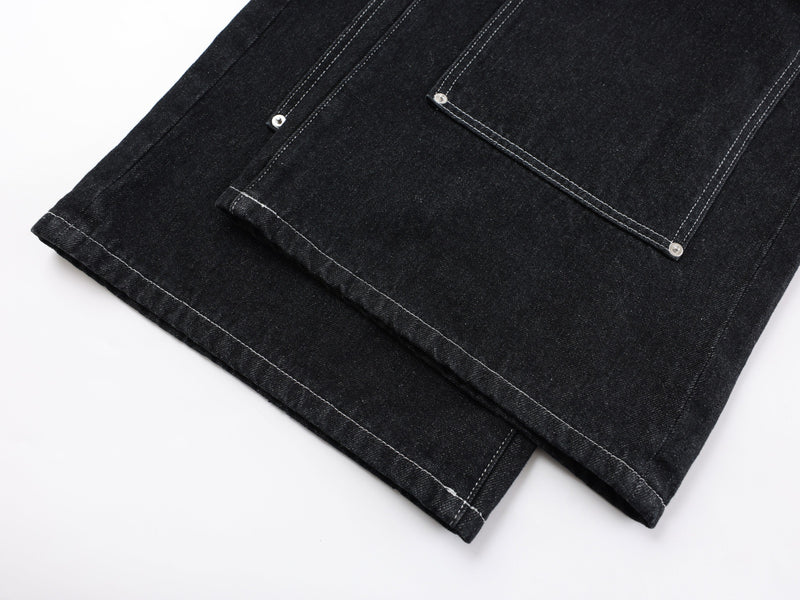 Close-up of hem and cargo pocket details on black denim pants